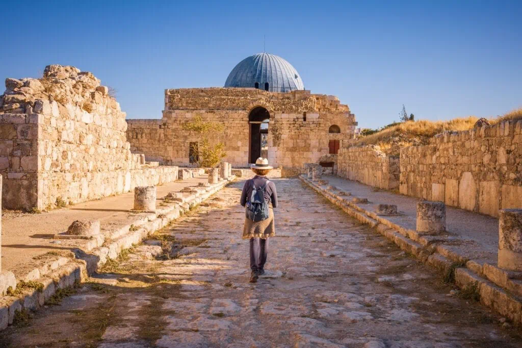 Lady walking along Colonnated Street toward the Monumental Gateway at Umayyad Palace, Amman Citadel, Amman, Jordan