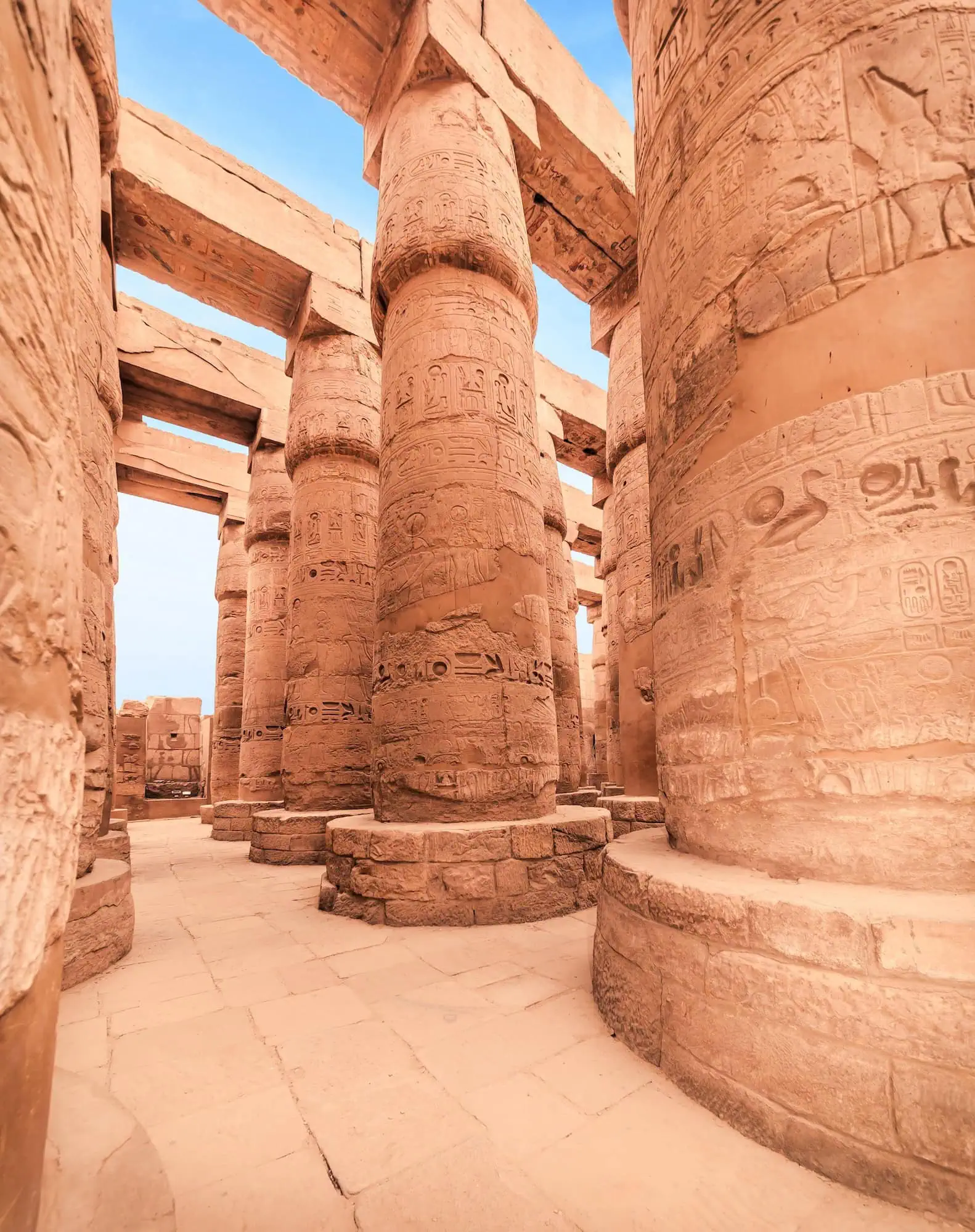 Interior view of Karnak Temple's Great Hypostyle Hall showing massive columns with hieroglyphic carvings