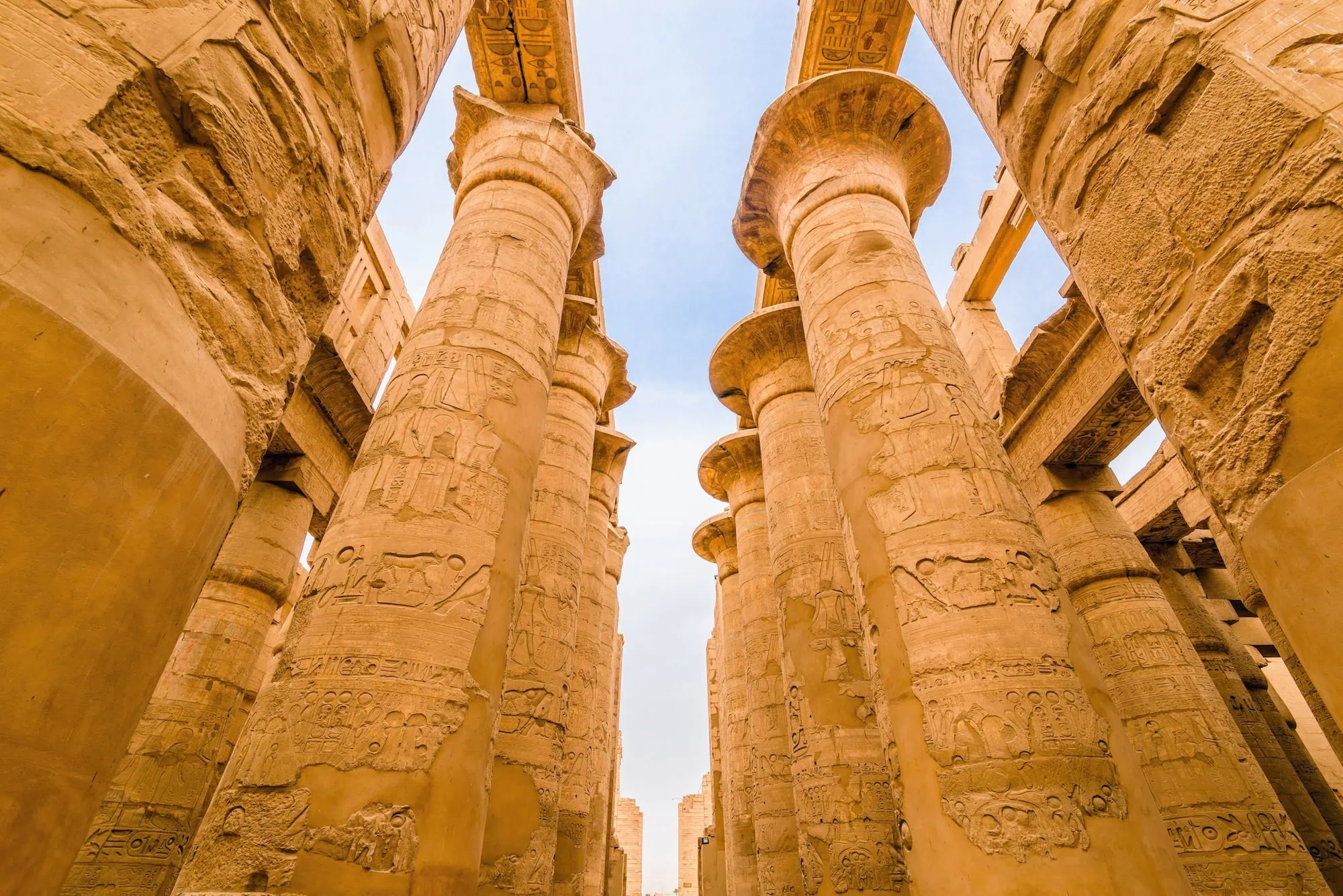 Massive ancient Egyptian columns with hieroglyphic carvings in the Great Hypostyle Hall at Karnak Temple