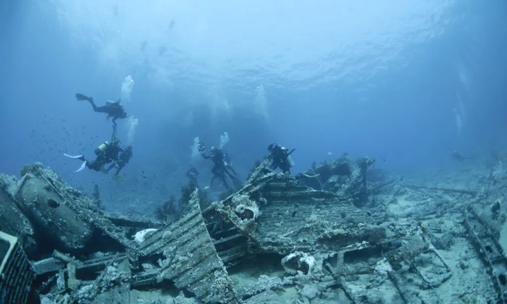 Scuba divers exploring the wreck of a cargo ship at Yolanda Reef in Ras Mohammed National Park, Sharm El Sheikh