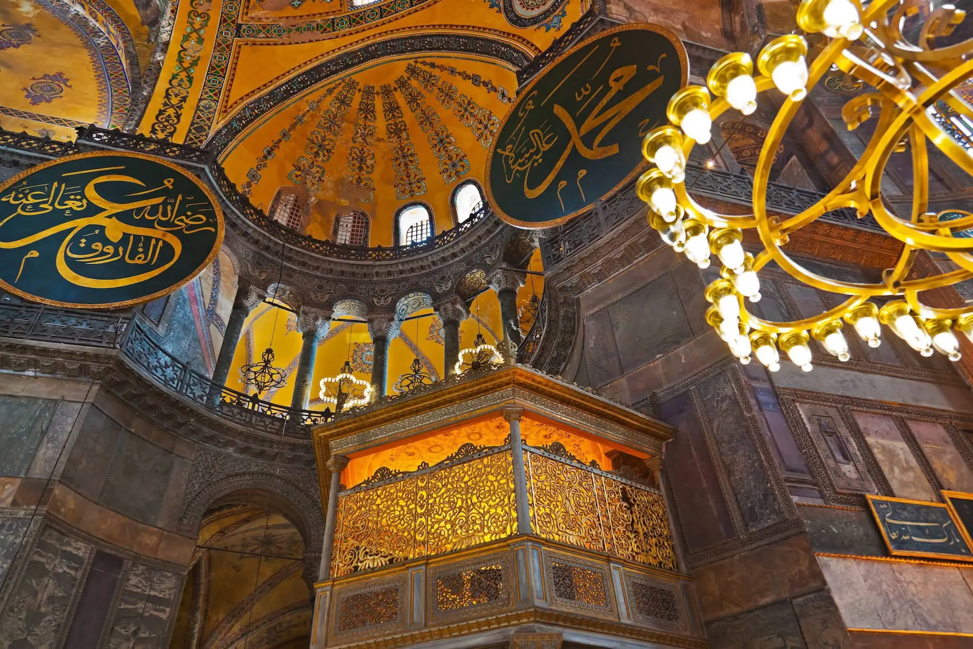 Interior view of Hagia Sophia showing magnificent dome, Islamic calligraphy, marble columns and ornate Byzantine-Islamic architecture