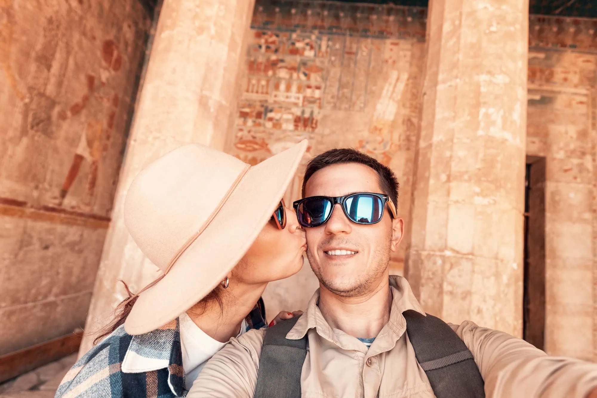 Tourist wearing hat and sunglasses at Luxor Temple showing respectful cultural customs