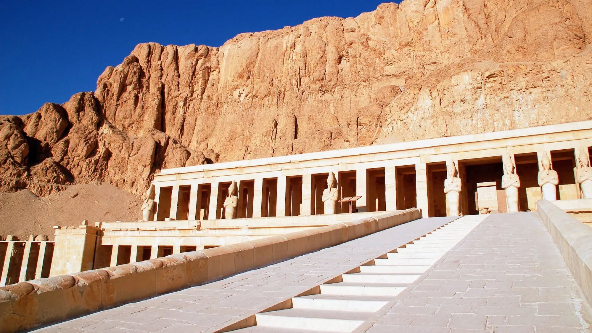 Ancient Temple of Hatshepsut with columns and stairs built into dramatic cliffs at Deir el-Bahari