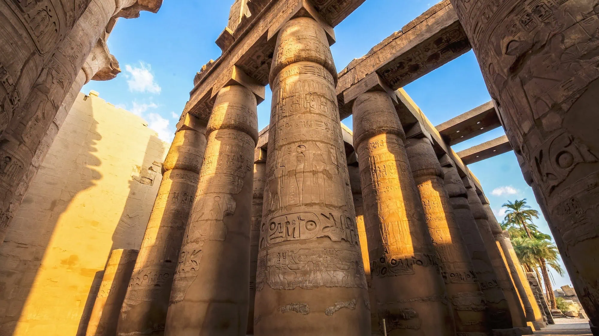 Massive stone columns with hieroglyphic carvings in the Great Hypostyle Hall at Karnak Temple