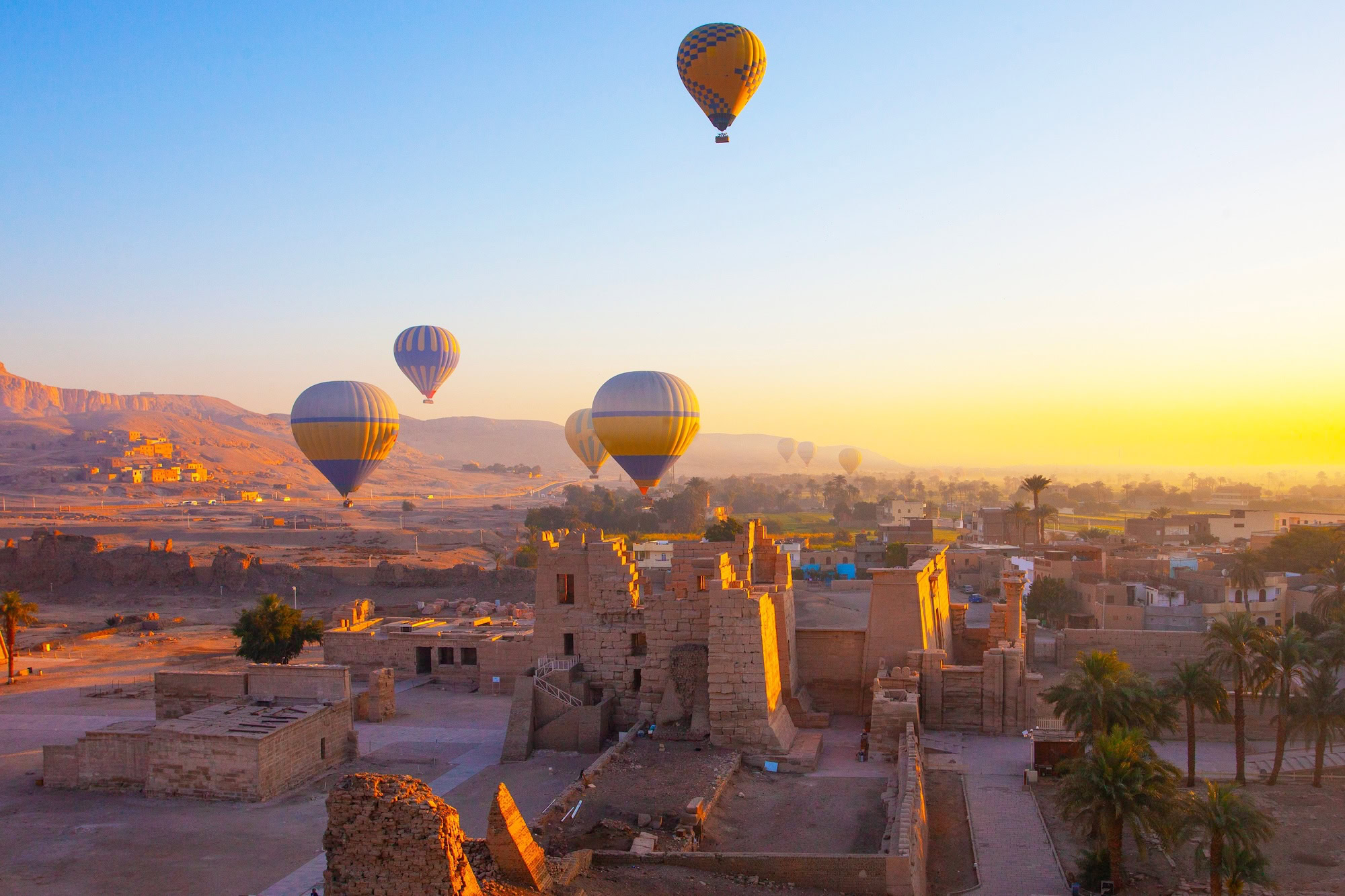 Hot air balloons floating over ancient temples and ruins in Luxor, Egypt