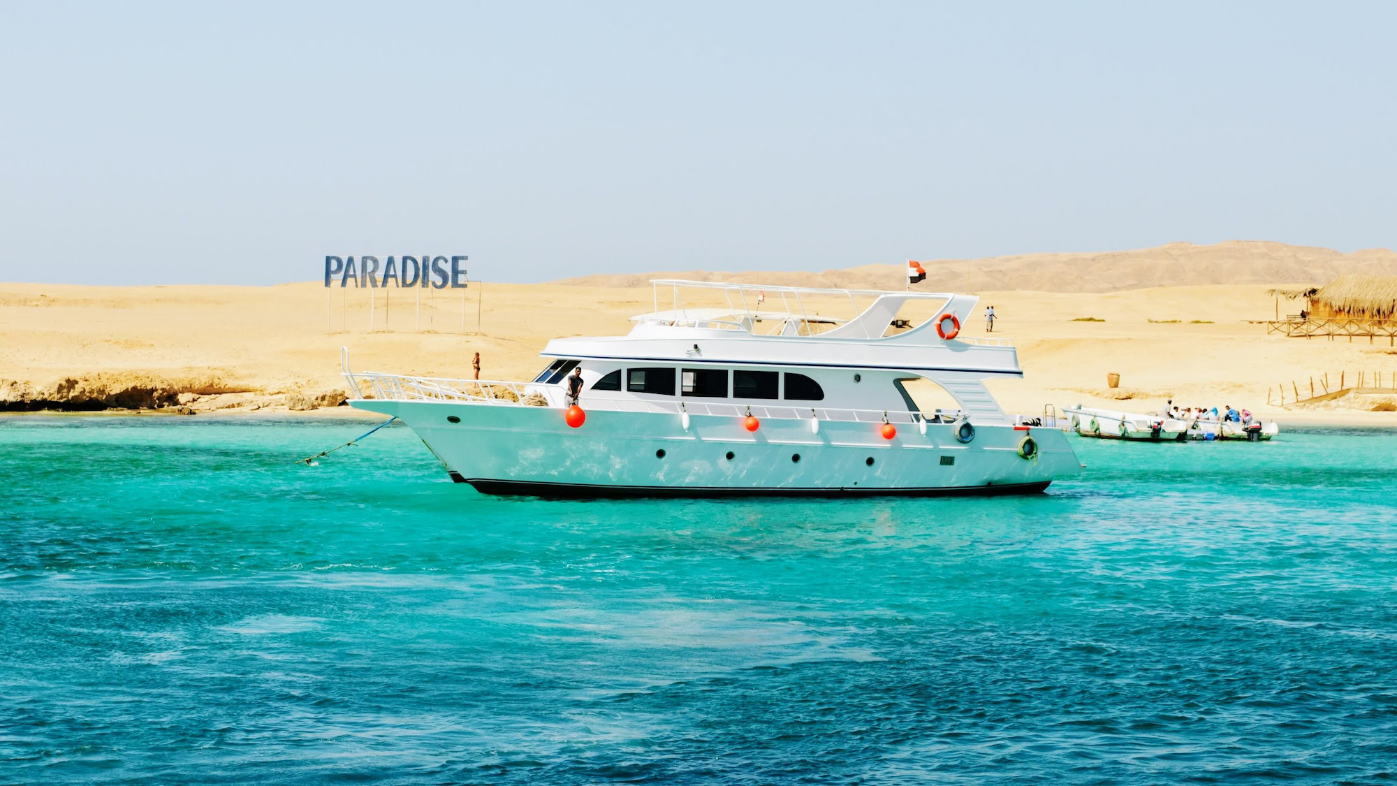 Yacht on turquoise Red Sea waters with divers and swimming platform
