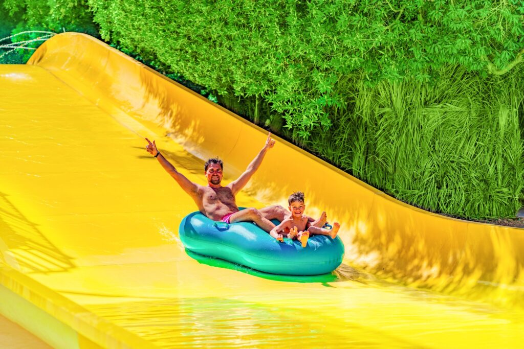 Father and son enjoying a water slide at a resort water park, Hurghada