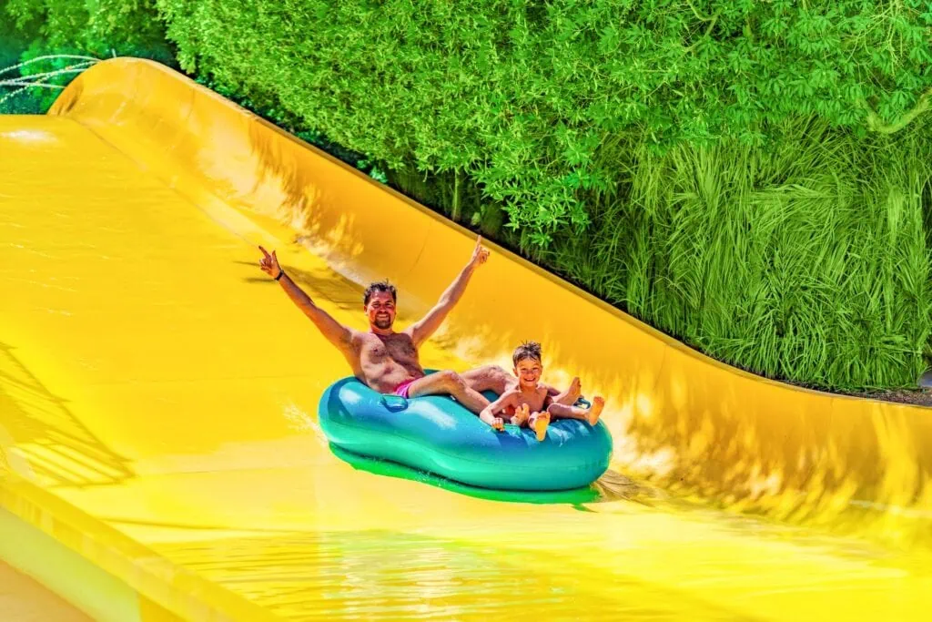 Father and son enjoying a water slide at a resort water park, Hurghada