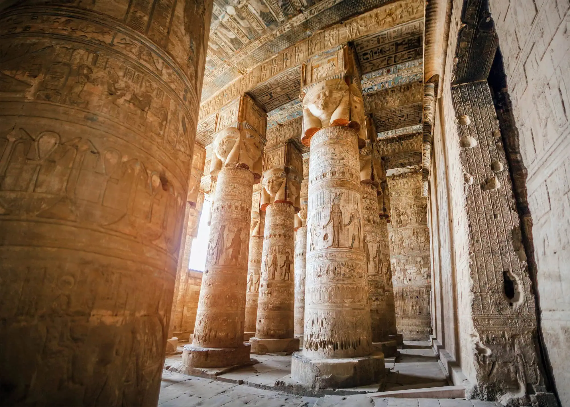 Interior of Temple of Hathor at Dendera showing carved columns with Hathor capitals and hieroglyphic reliefs