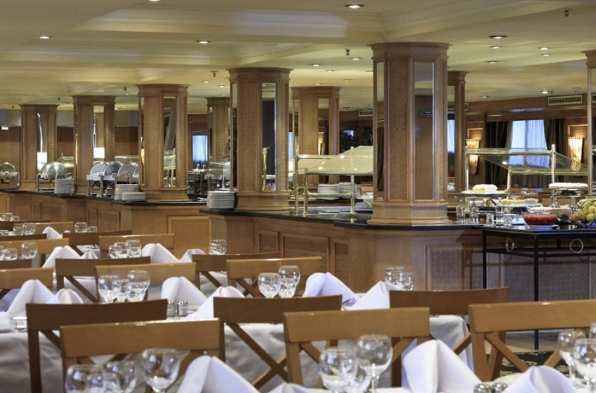 Elegant cruise ship restaurant dining room with white linens and wine service