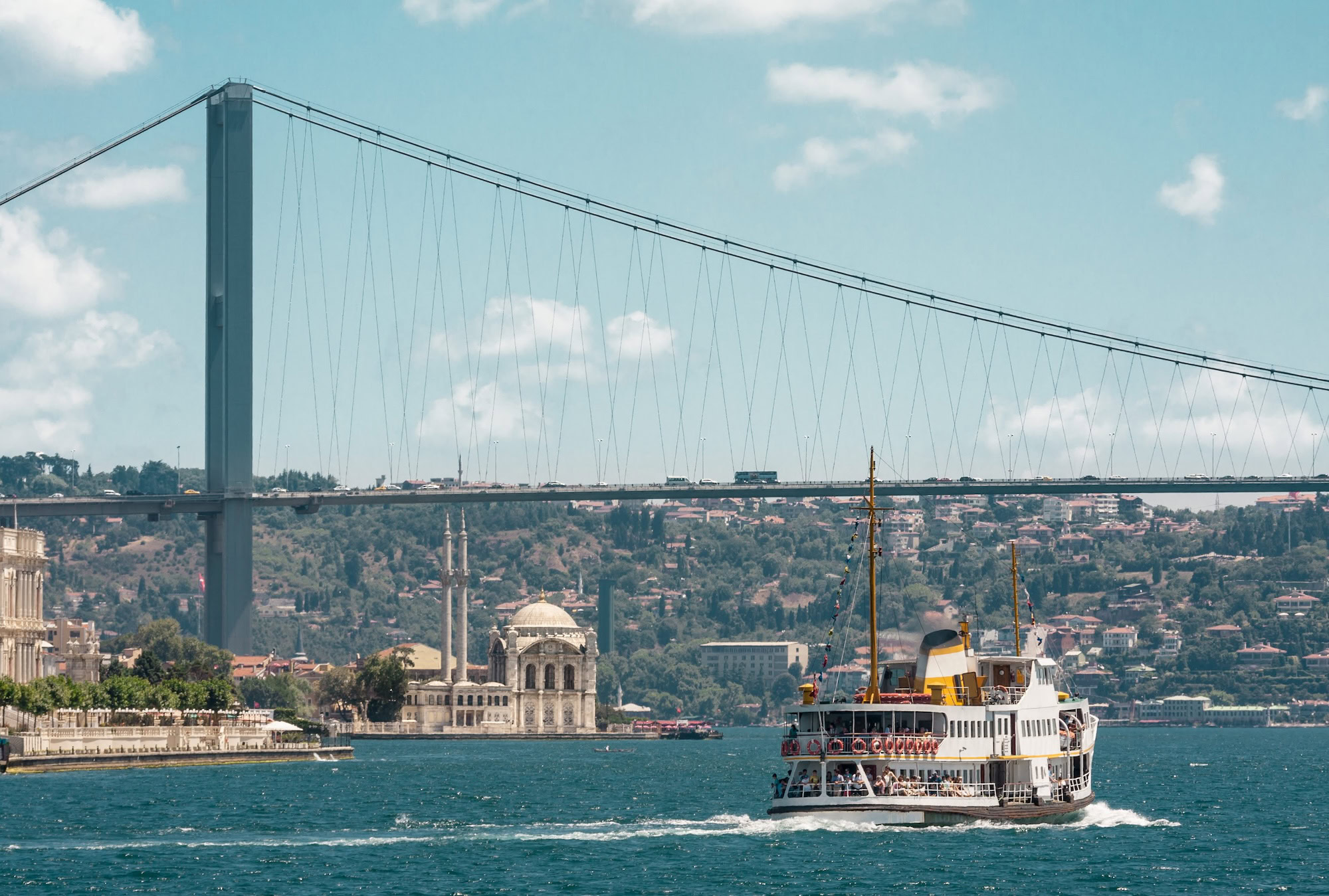 Bosphorus Bridge with ferry boat and mosque minarets in Istanbul