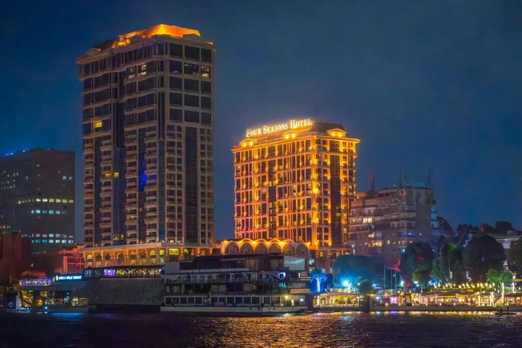 Illuminated Four Seasons Hotel building along the Nile River at night in downtown Cairo, Cairo