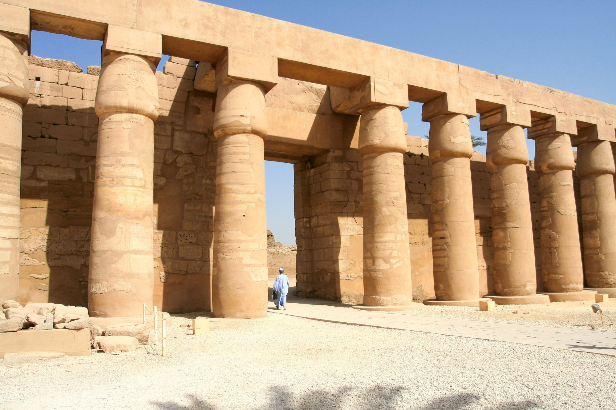 Person walking through ancient Egyptian temple columns at Karnak