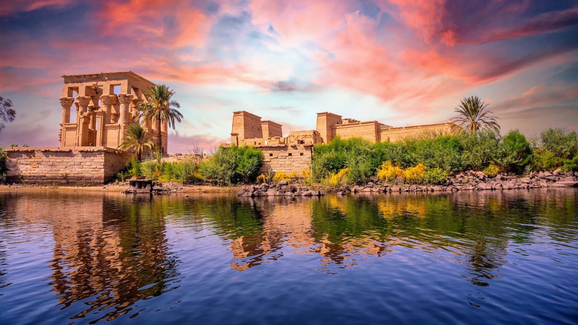 Sunrise view of Temple of Philae reflected in Nile River waters on Agilkia Island near Aswan