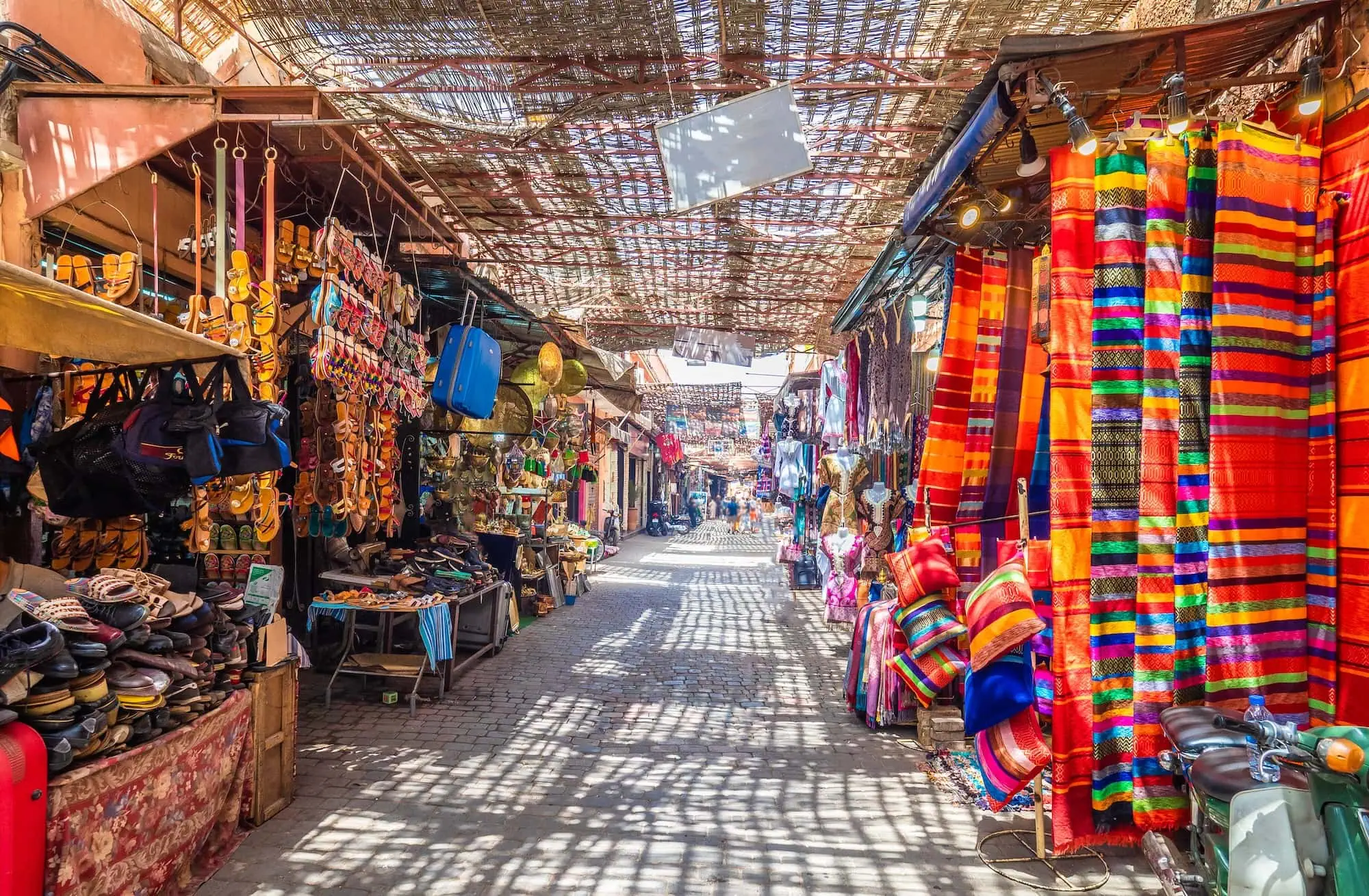 Traditional covered marketplace in Marrakech with colorful textiles and souvenirs