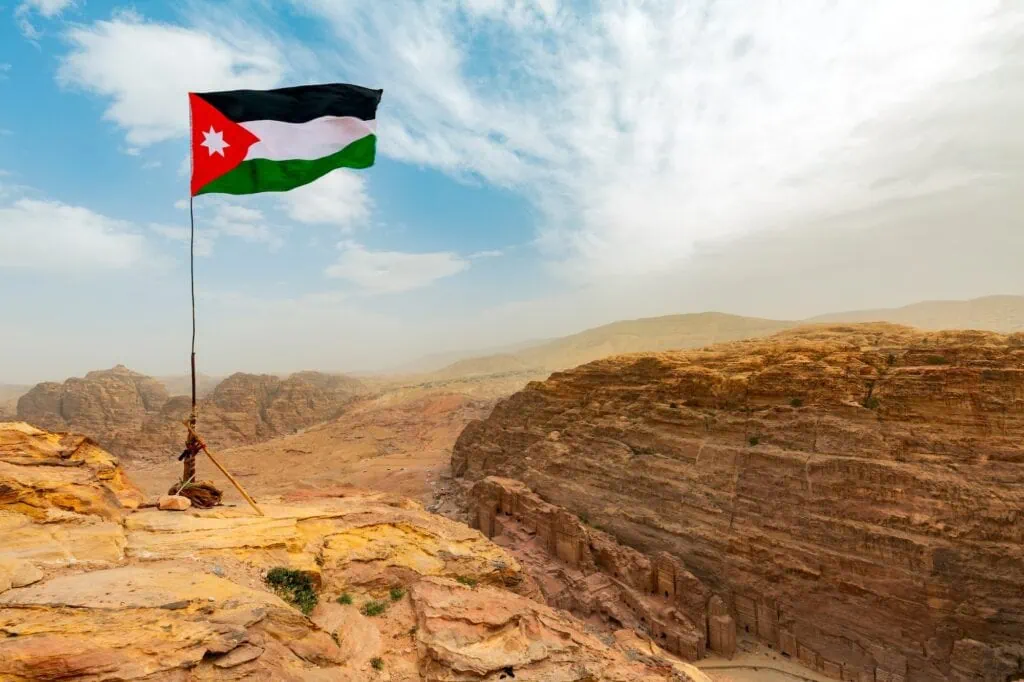 Jordan flag waving on a sunny and windy day in Petra landscape Jordan