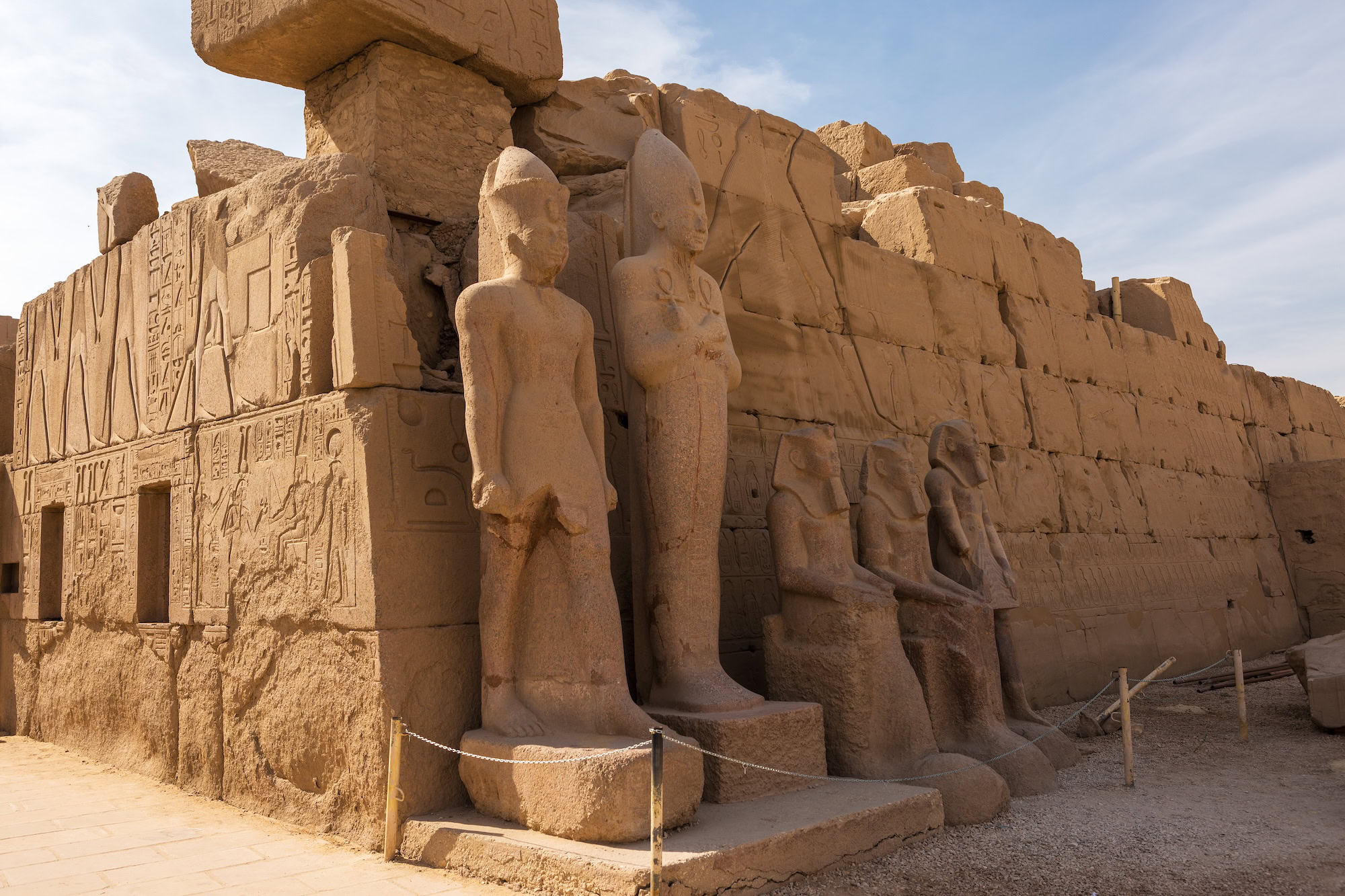 Ancient Egyptian temple with stone statues and hieroglyphic carvings on walls