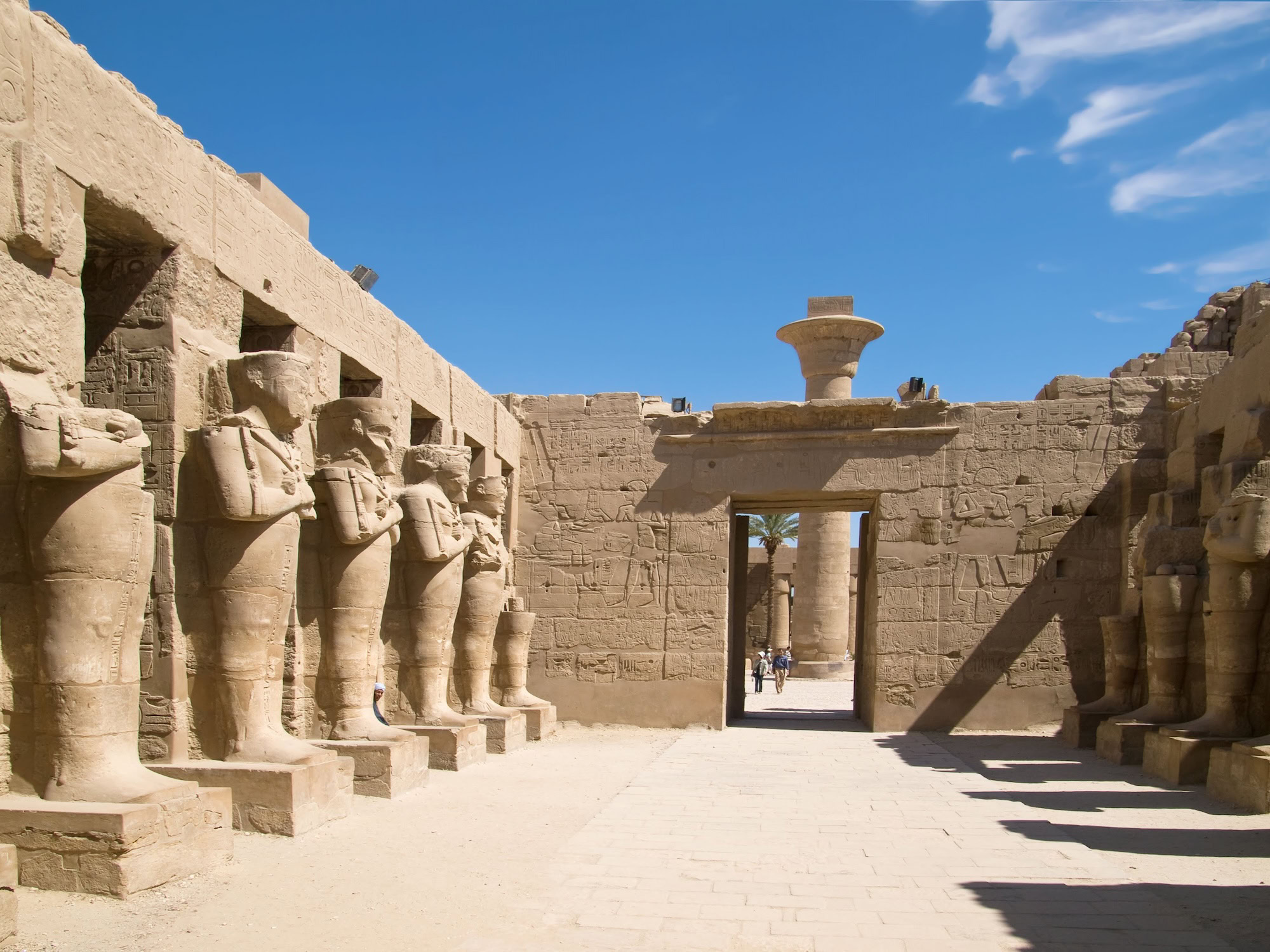 Tourists exploring the majestic columns and hieroglyphs at Karnak Temple Complex
