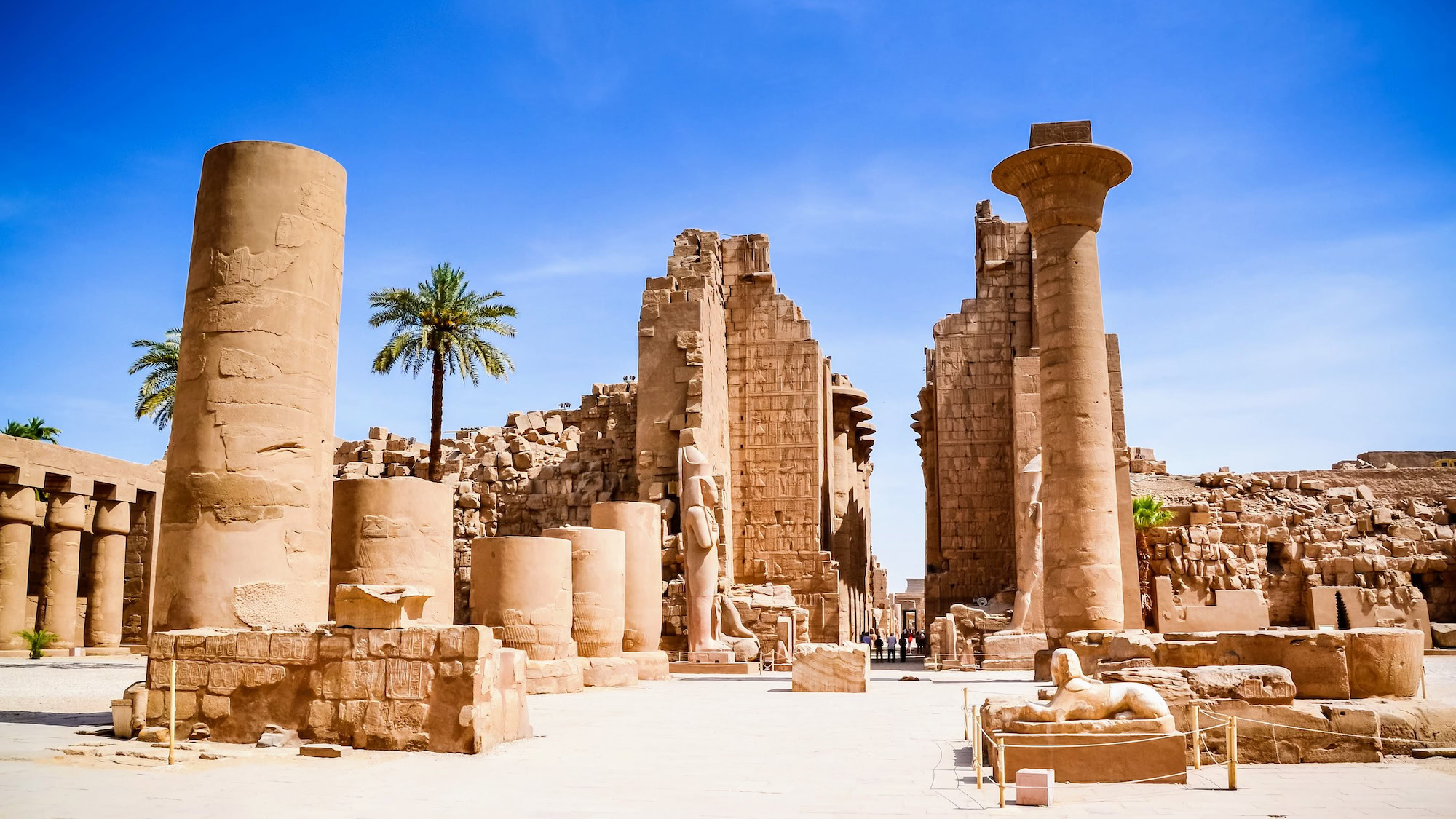 Ancient Egyptian temple complex at Karnak with tourists exploring the archaeological site