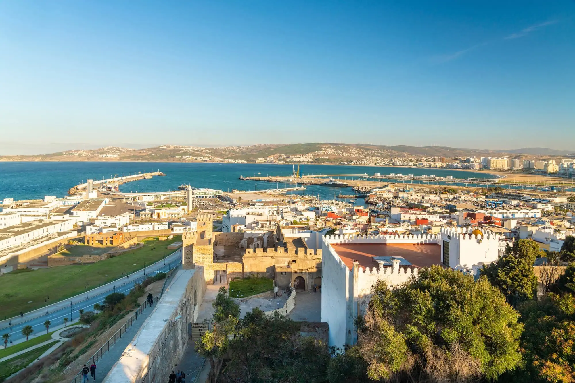 Aerial view of Tangier's historic Kasbah fortress with white stone walls and coastal backdrop