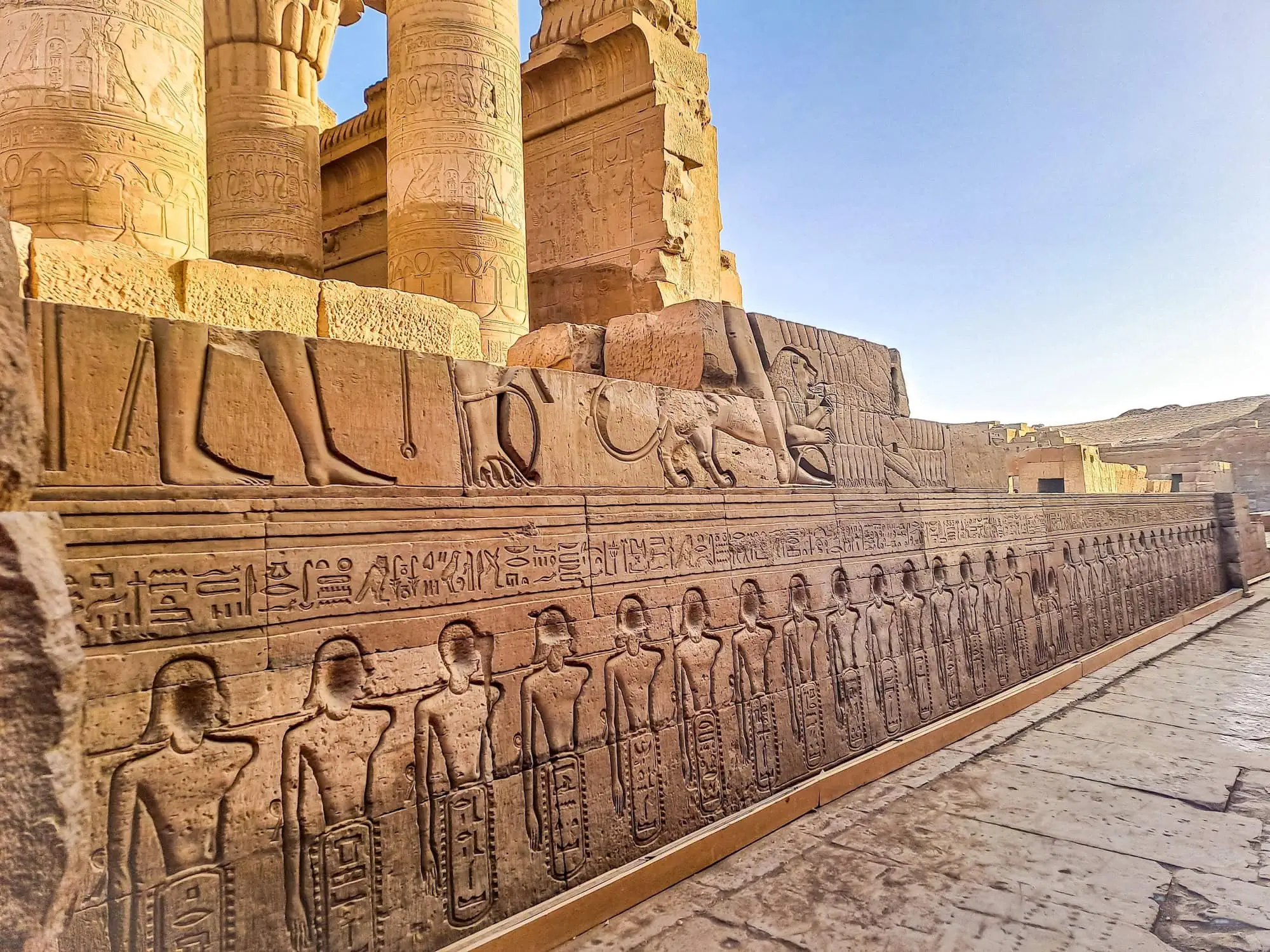 Kom Ombo Temple complex with hieroglyphic carvings and towering columns against blue sky