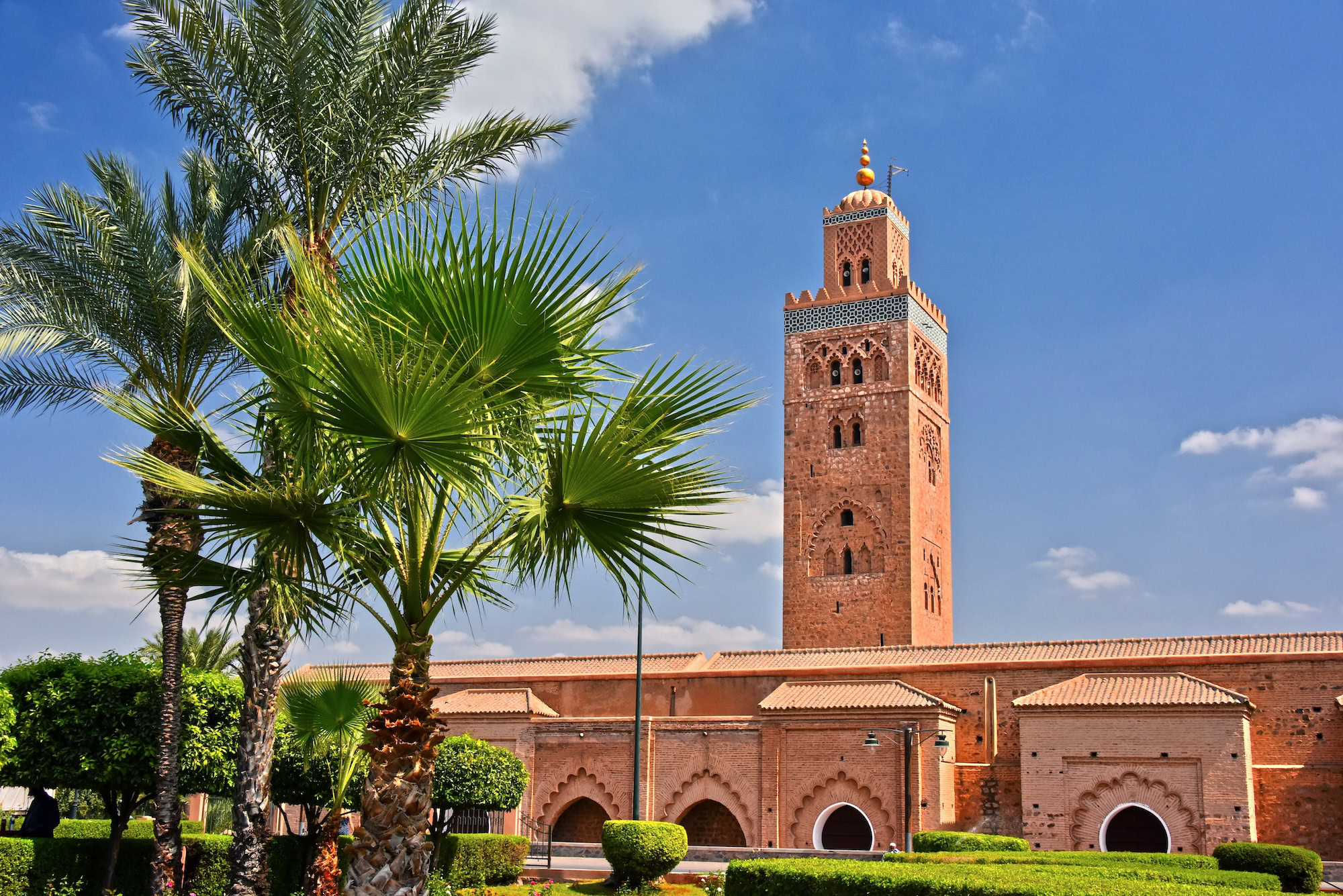 Koutoubia Mosque minaret surrounded by palm trees and gardens in Marrakech
