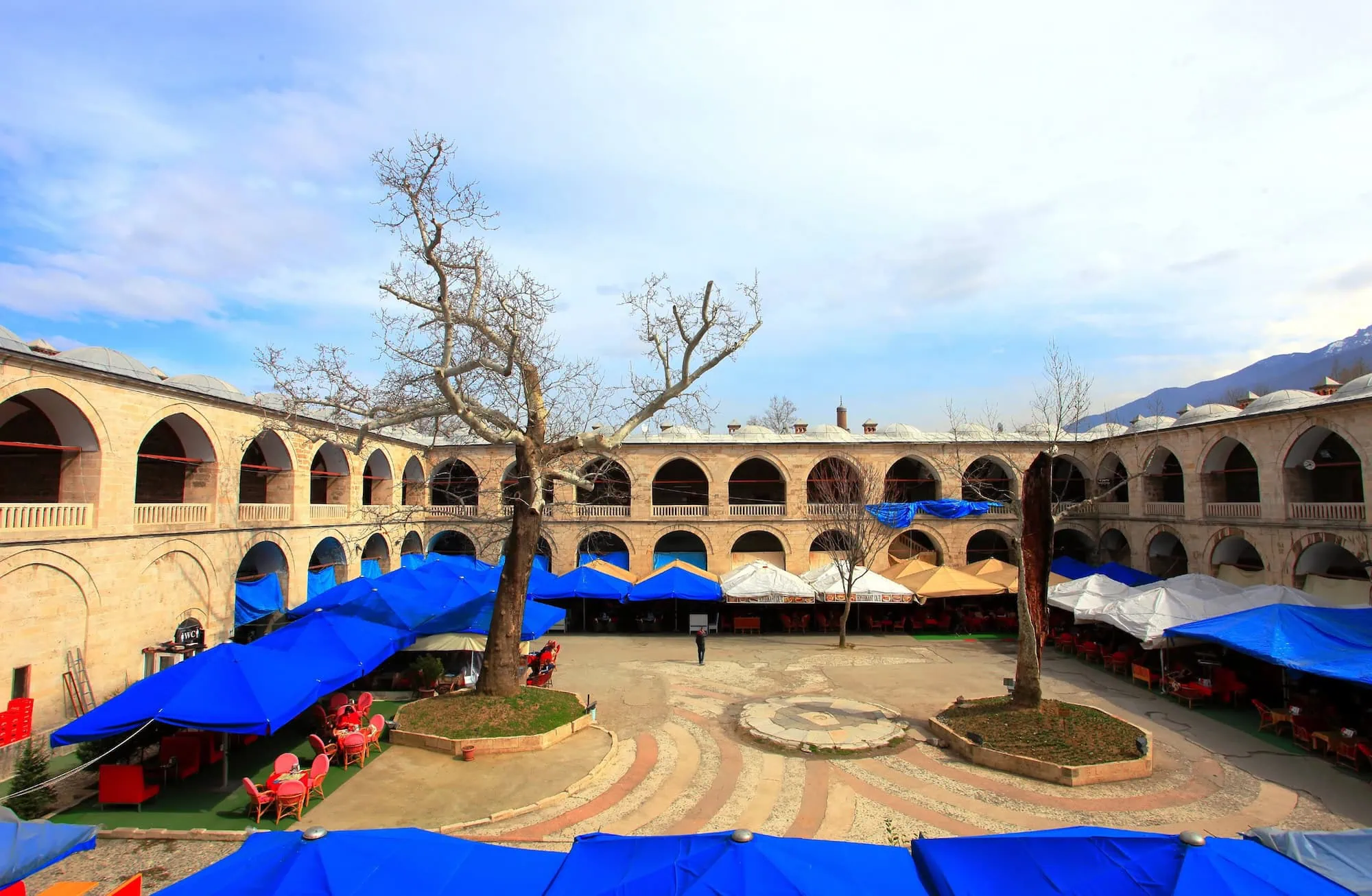 Historic Koza Han courtyard showing traditional Ottoman architecture with two-story arched galleries
