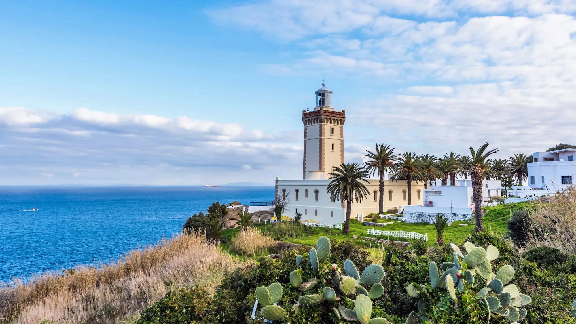 Cape Spartel lighthouse on cliff overlooking blue sea with Mediterranean vegetation