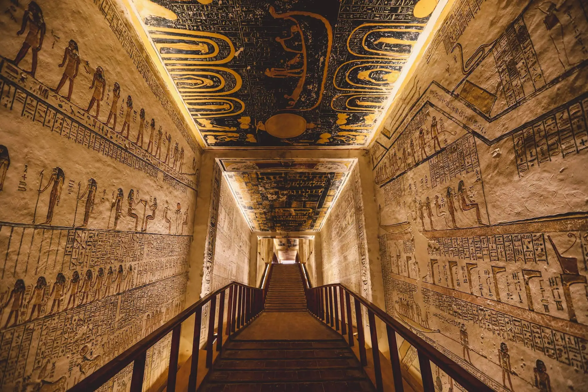 Interior of ancient Egyptian pharaoh tomb with hieroglyphic wall paintings and decorative ceiling