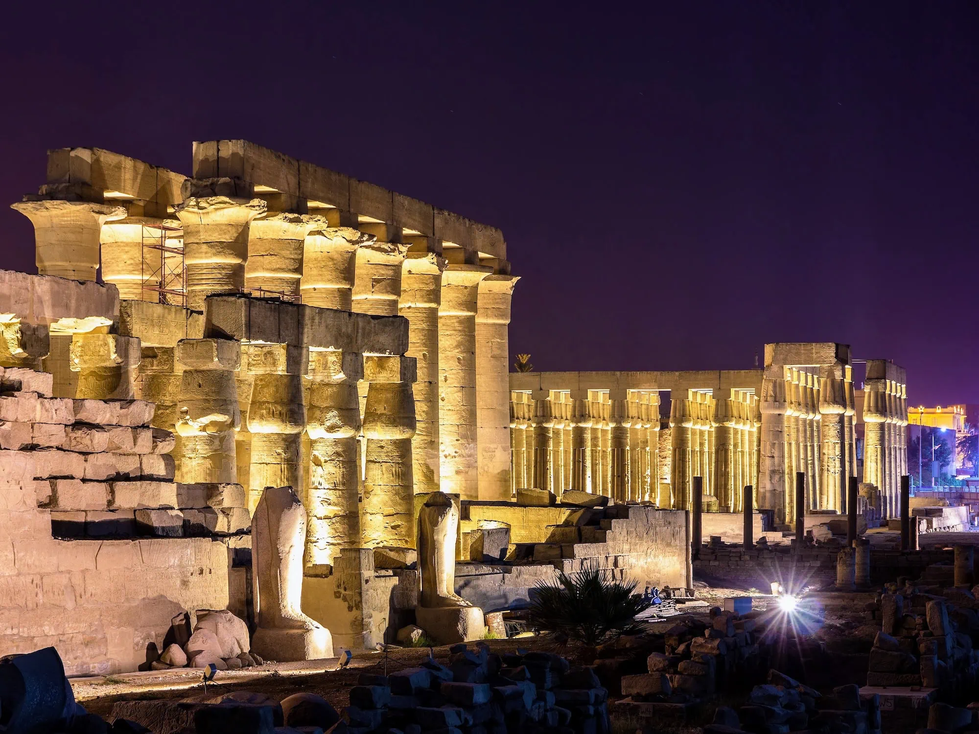 Luxor Temple illuminated at night with golden lighting highlighting ancient Egyptian columns and architecture