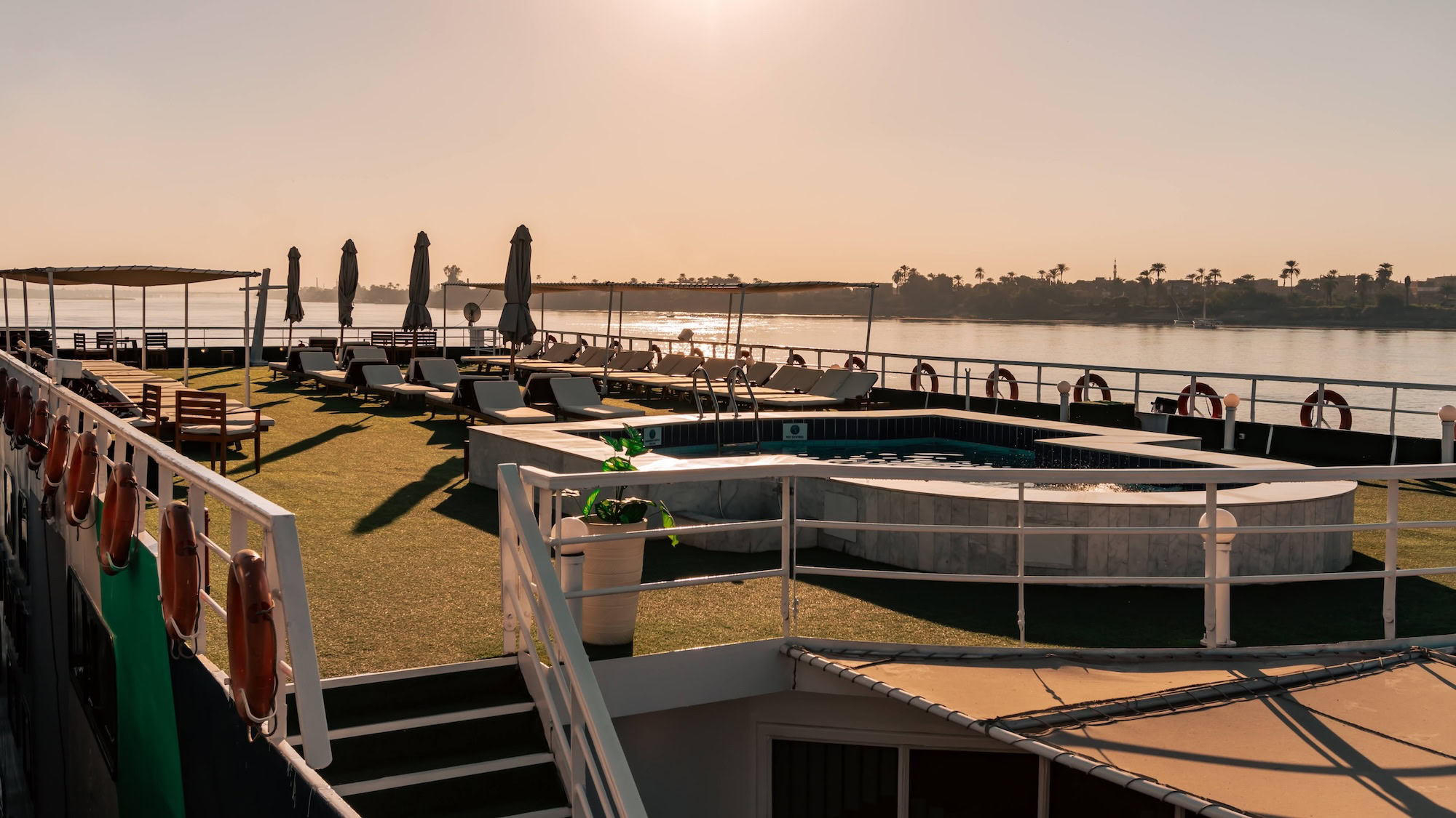Nile River cruise ship deck with empty pool and sun loungers