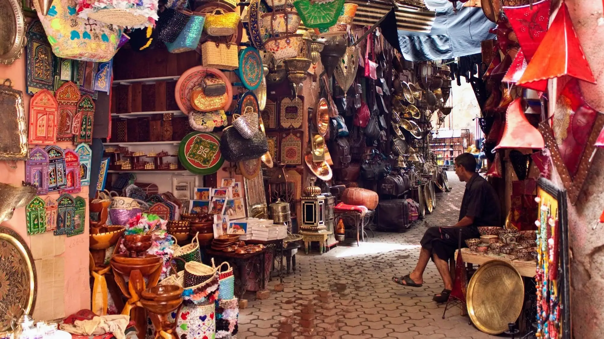 Traditional Moroccan bazaar with colorful vendor stalls and handicrafts in narrow alleyway