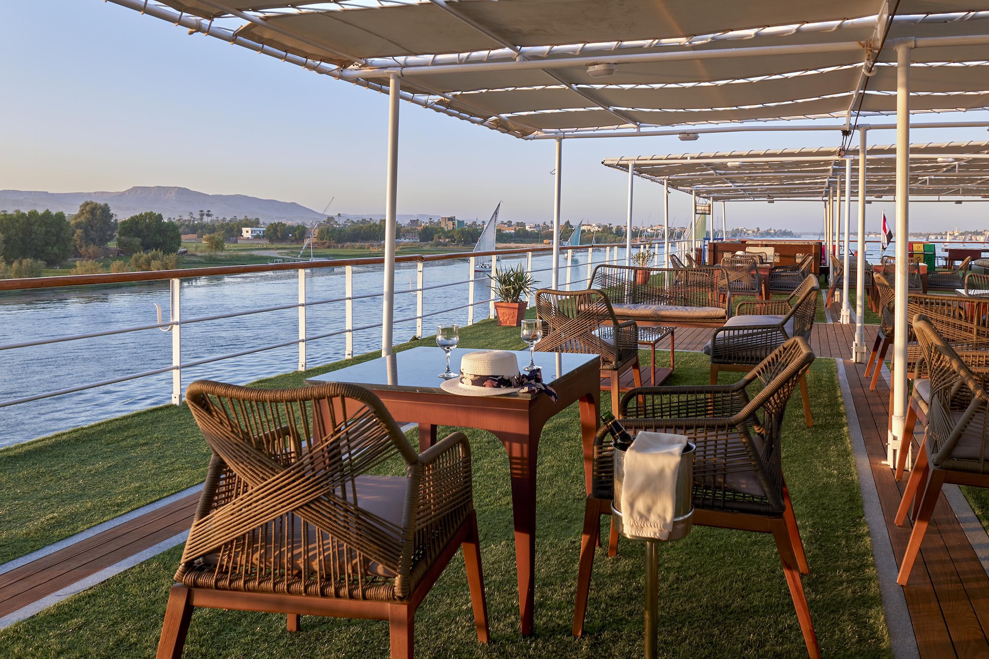 Elegant dining table with wine glasses on luxury Nile River cruise ship deck