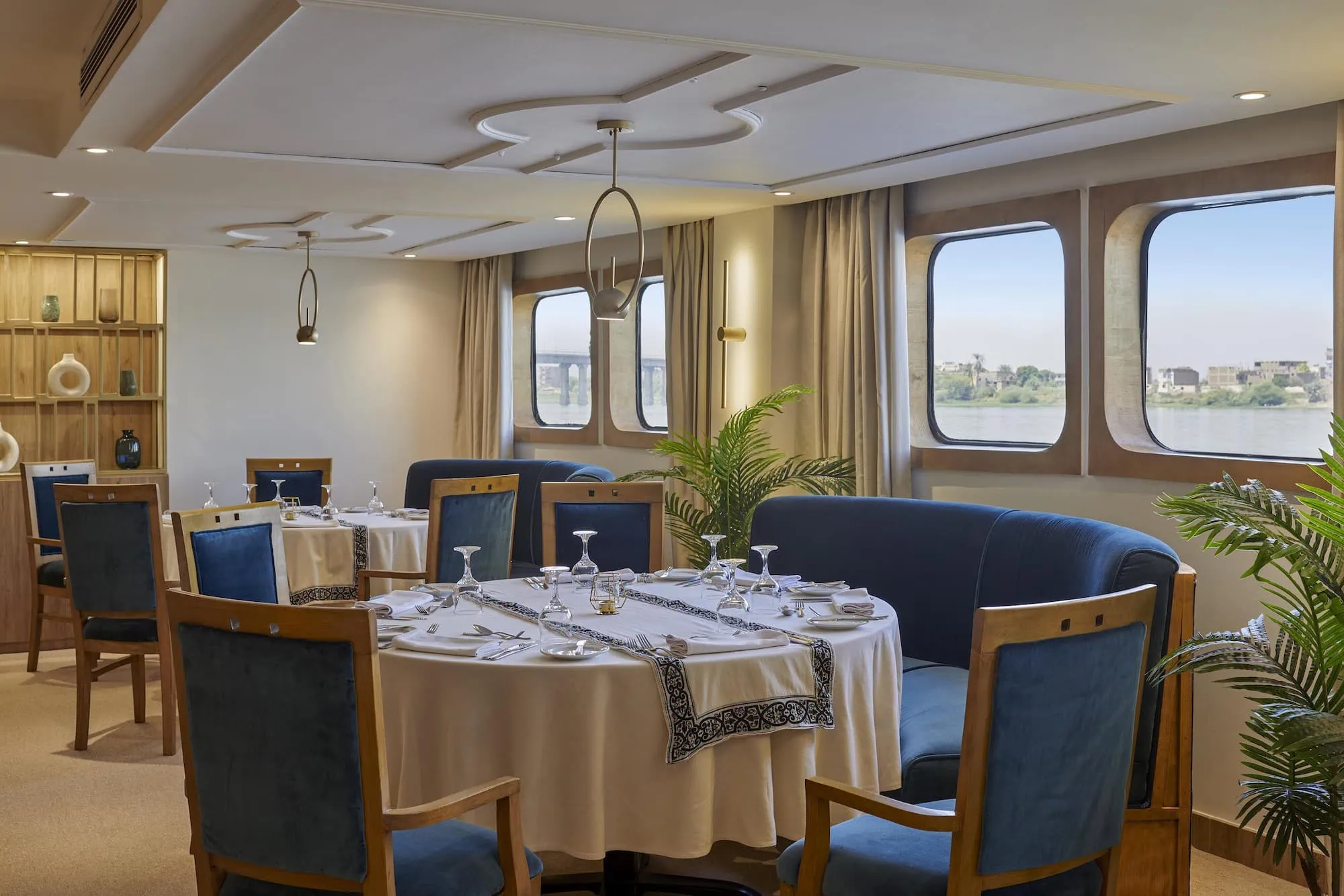 Elegant dining room aboard Nile River cruise ship with large windows overlooking the river
