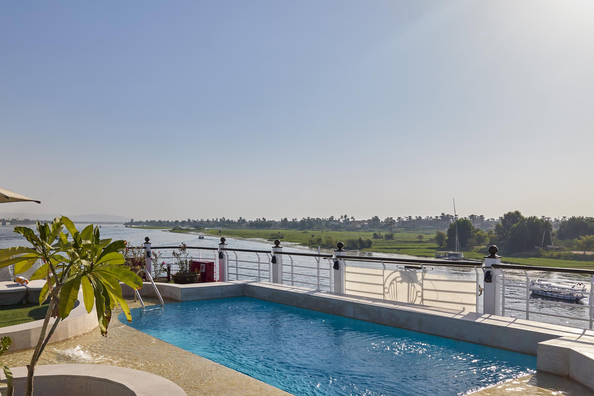 Luxurious Nile River cruise ship with swimming pool deck and palm trees