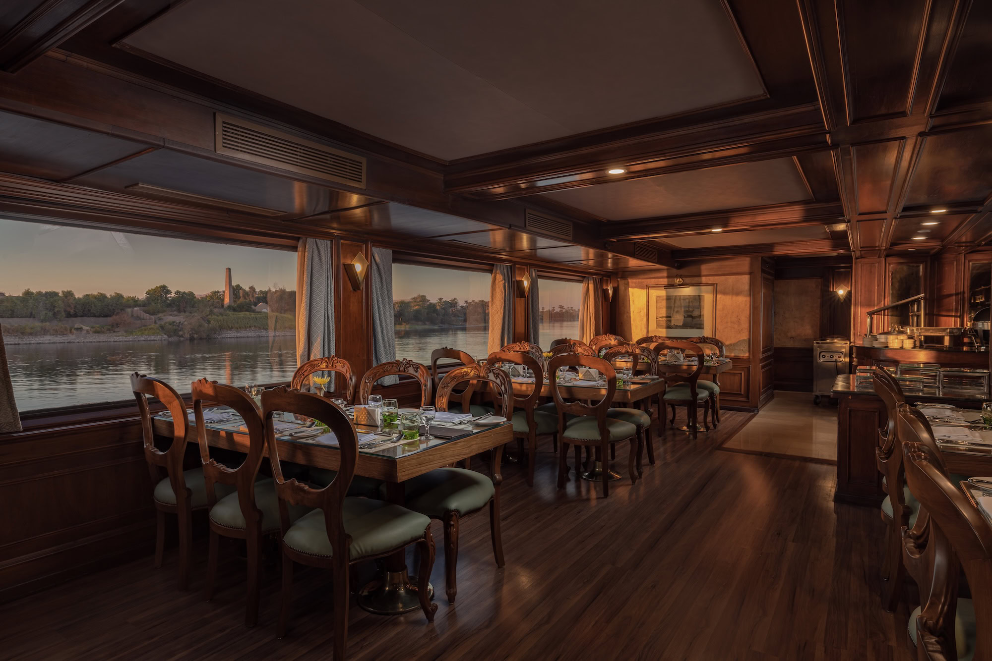 Elegant dining room interior on Nile River cruise ship with set tables and river views