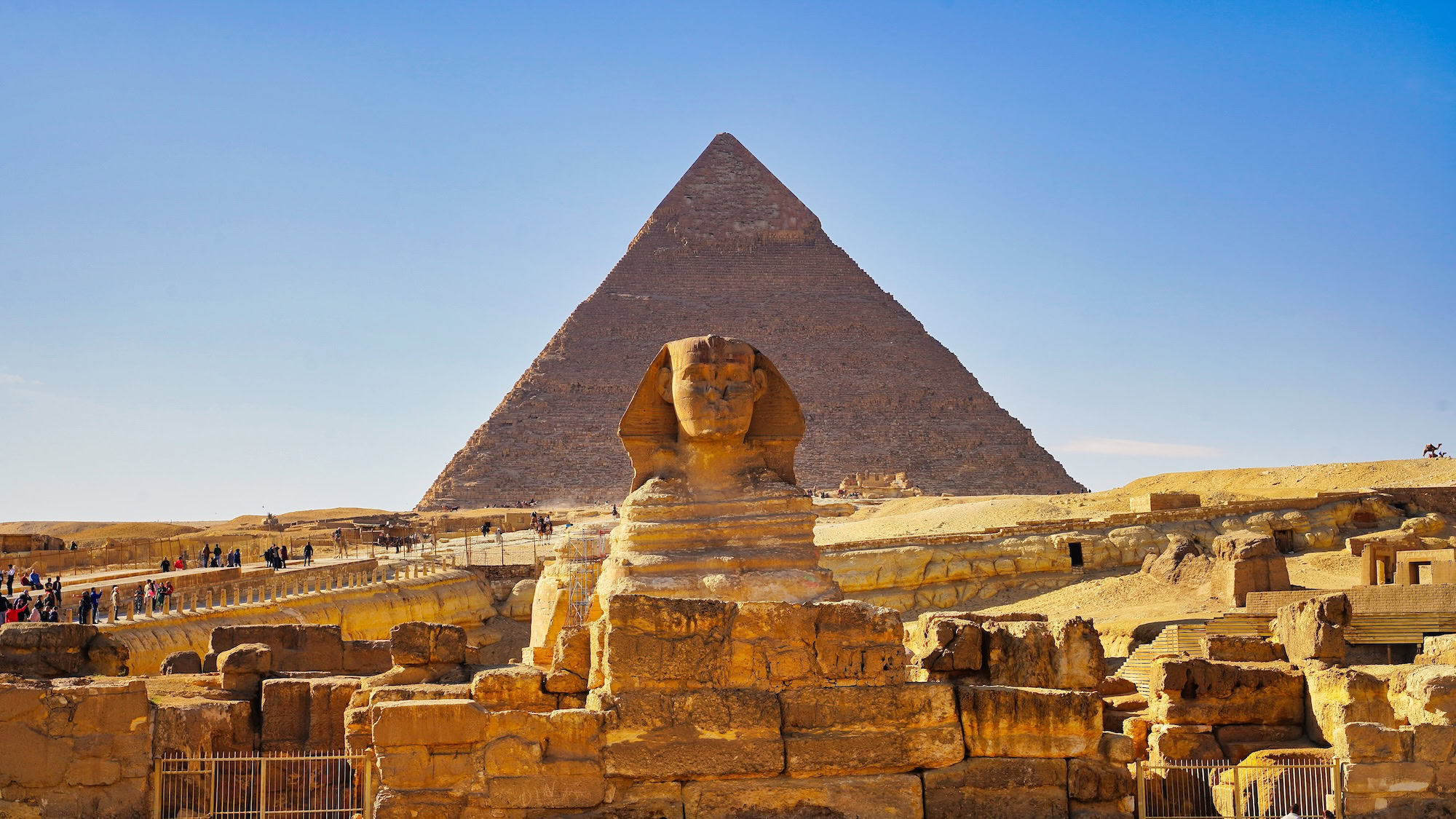 Great Sphinx of Giza with Pyramid of Khafre in background under blue sky