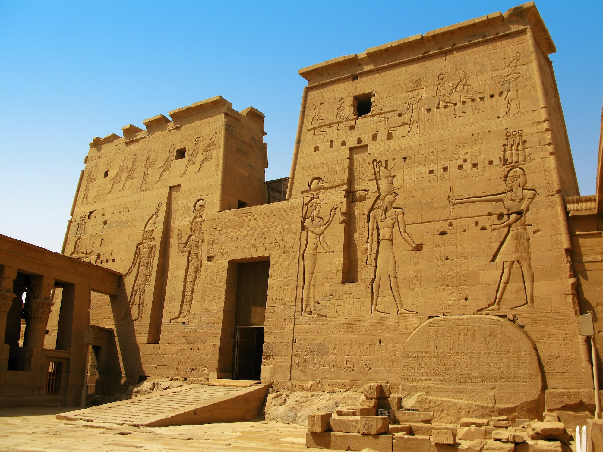 Ancient Philae Temple wall with detailed hieroglyphic carvings and Egyptian deity figures