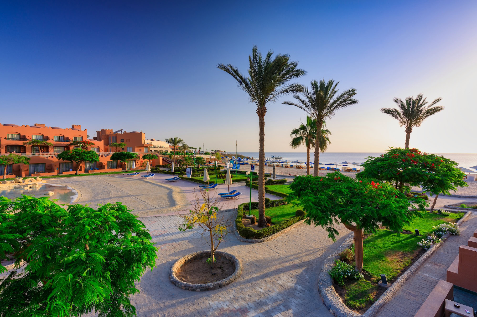 Red Sea resort complex with palm trees, beach, and tropical gardens