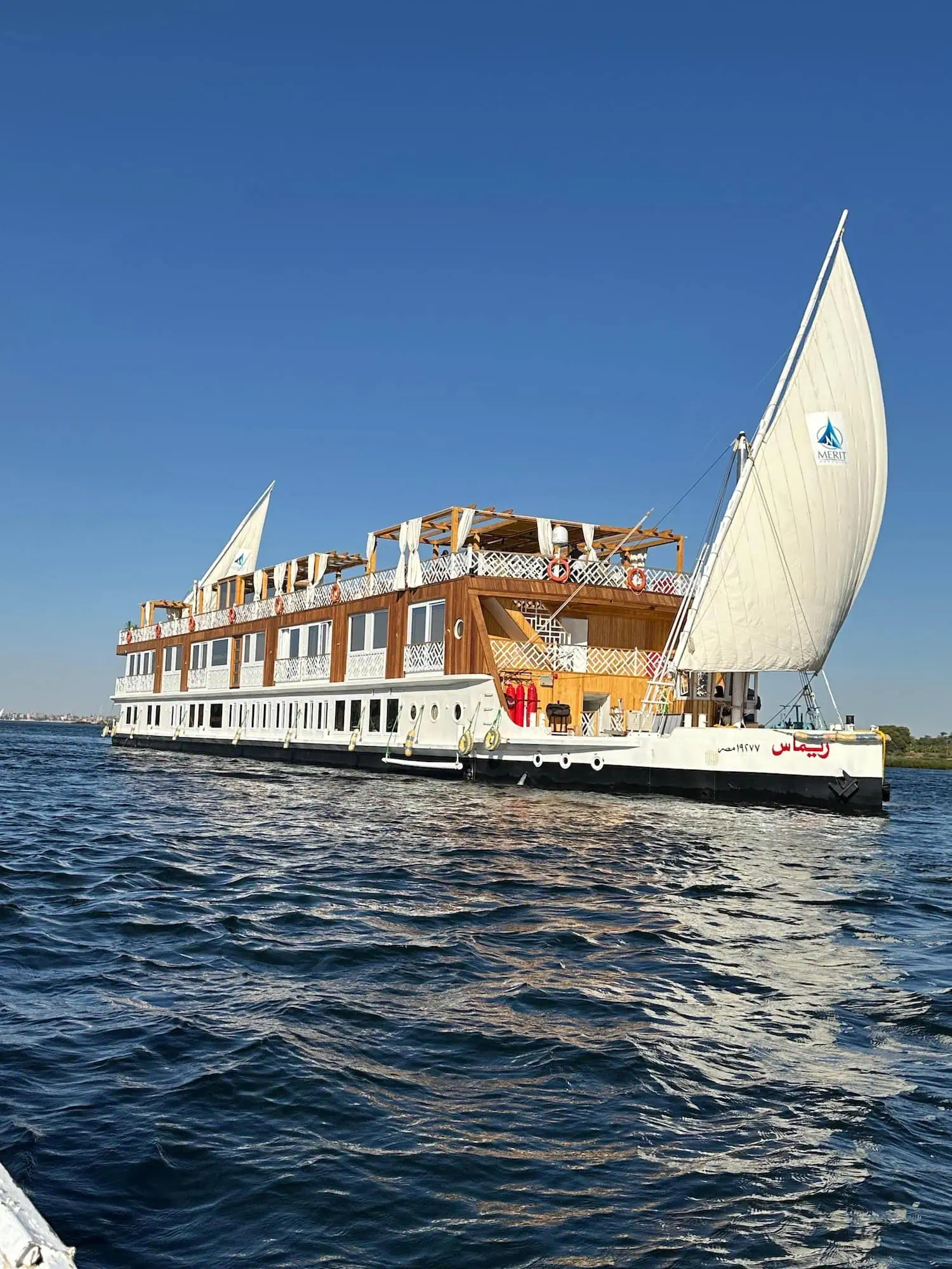 Traditional white-sailed dahabiya boat on the Nile River