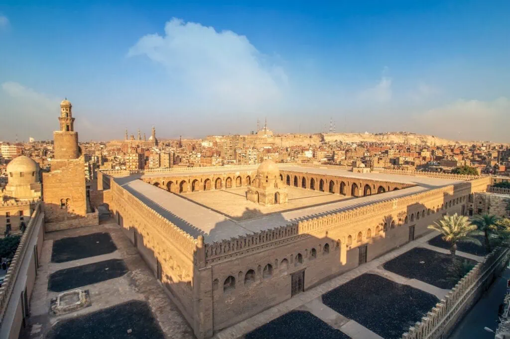 A top view showing the vast courtyard, surrounding arcades, and spiral minaret of the Mosque of Ahmad Ibn Tulun, Cairo