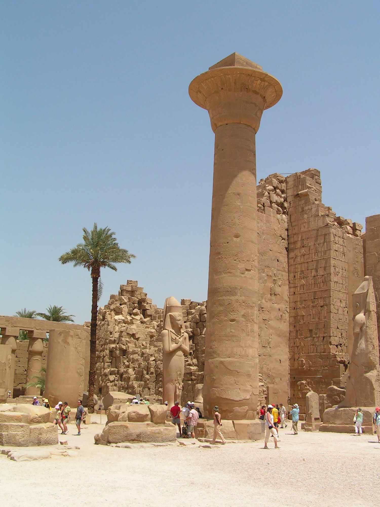 Tourists exploring ancient columns and hieroglyphs at Karnak Temple Complex in Luxor