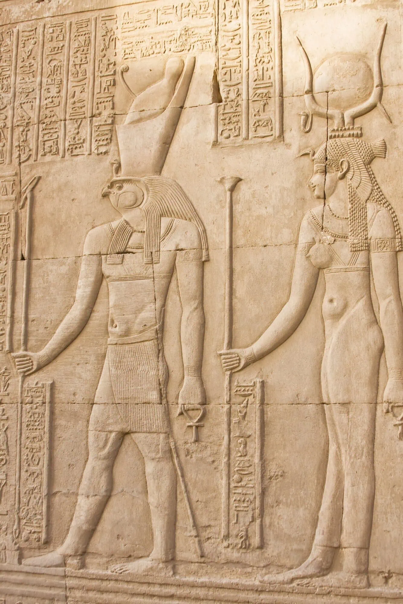 Ancient Egyptian stone relief showing Horus and Hathor deities with hieroglyphic inscriptions at Kom Ombo Temple