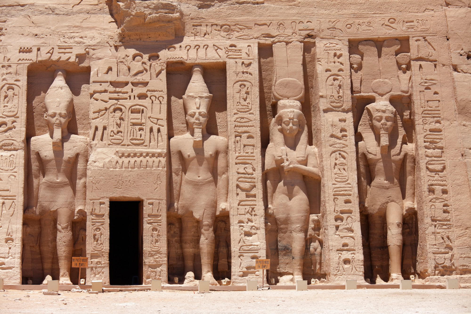 Abu Simbel temple facade with colossal pharaoh statues and entrance doorway