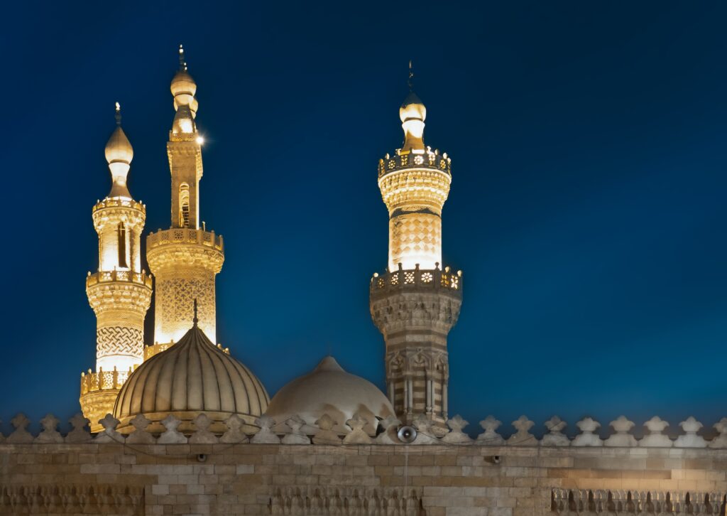 A night view showing illuminated minarets and the central dome of Al-Azhar Mosque, Cairo