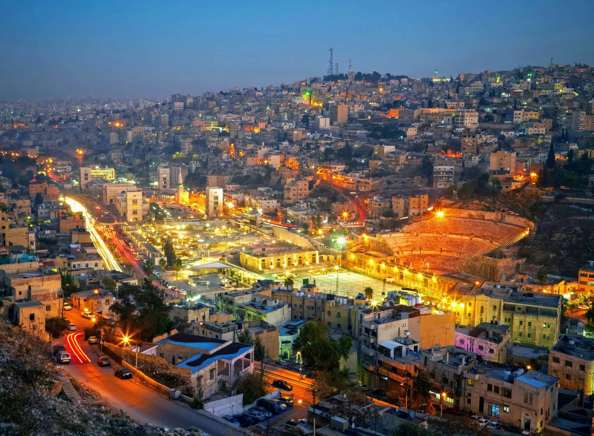 Illuminated Roman Theatre of Amman at night in the cityscape of Jordan's capital