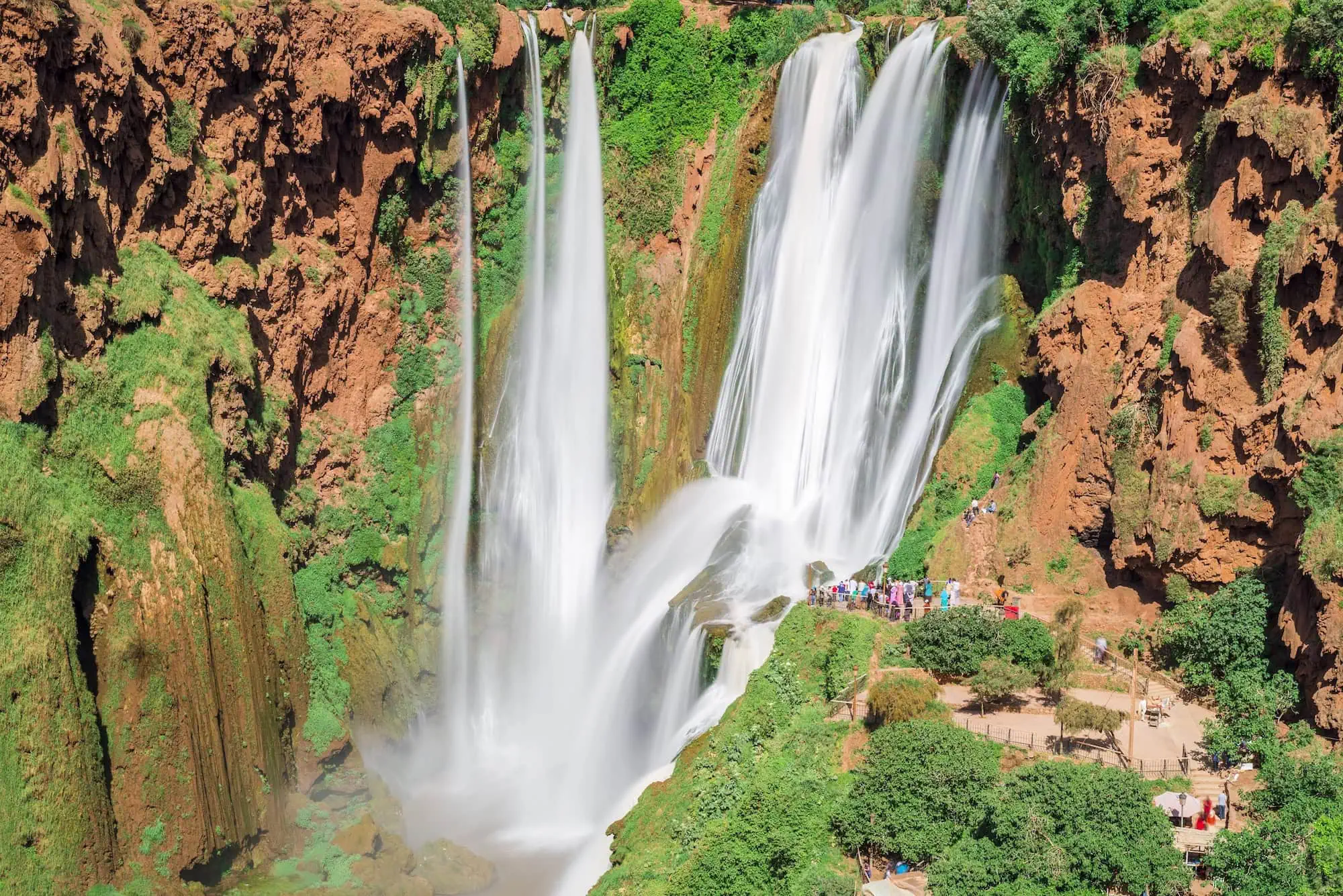 Aerial view of Ouzoud Waterfalls with tourists on viewing platforms for waterfall hiking