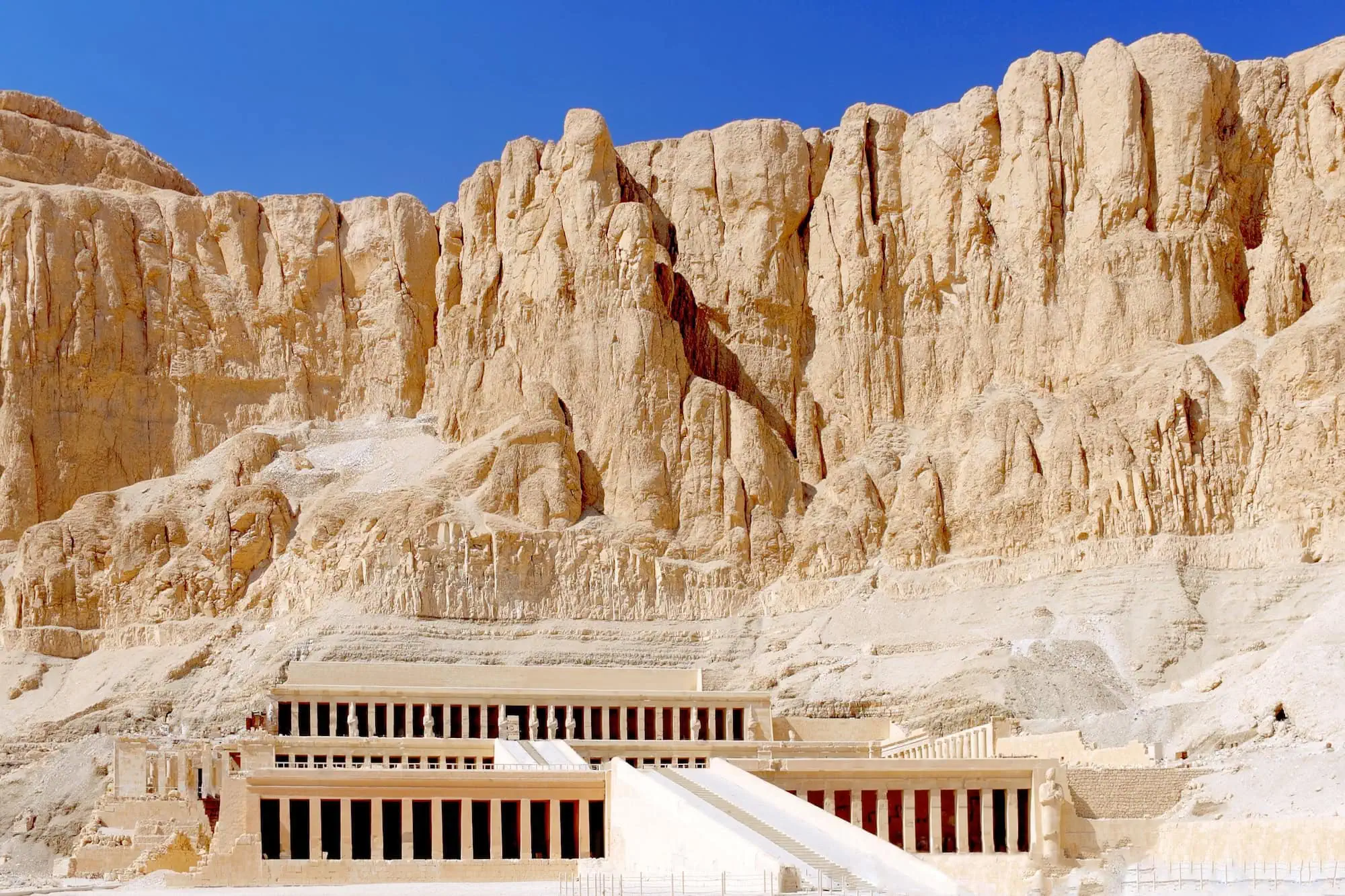 Vista majestosa do Templo de Hatshepsut com terraços de pedra calcária contra as falésias do Vale dos Reis