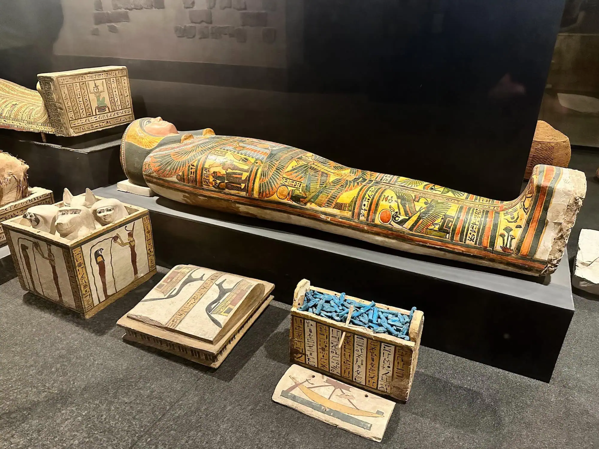Ancient Egyptian painted wooden sarcophagus and funerary objects displayed in Luxor Museum