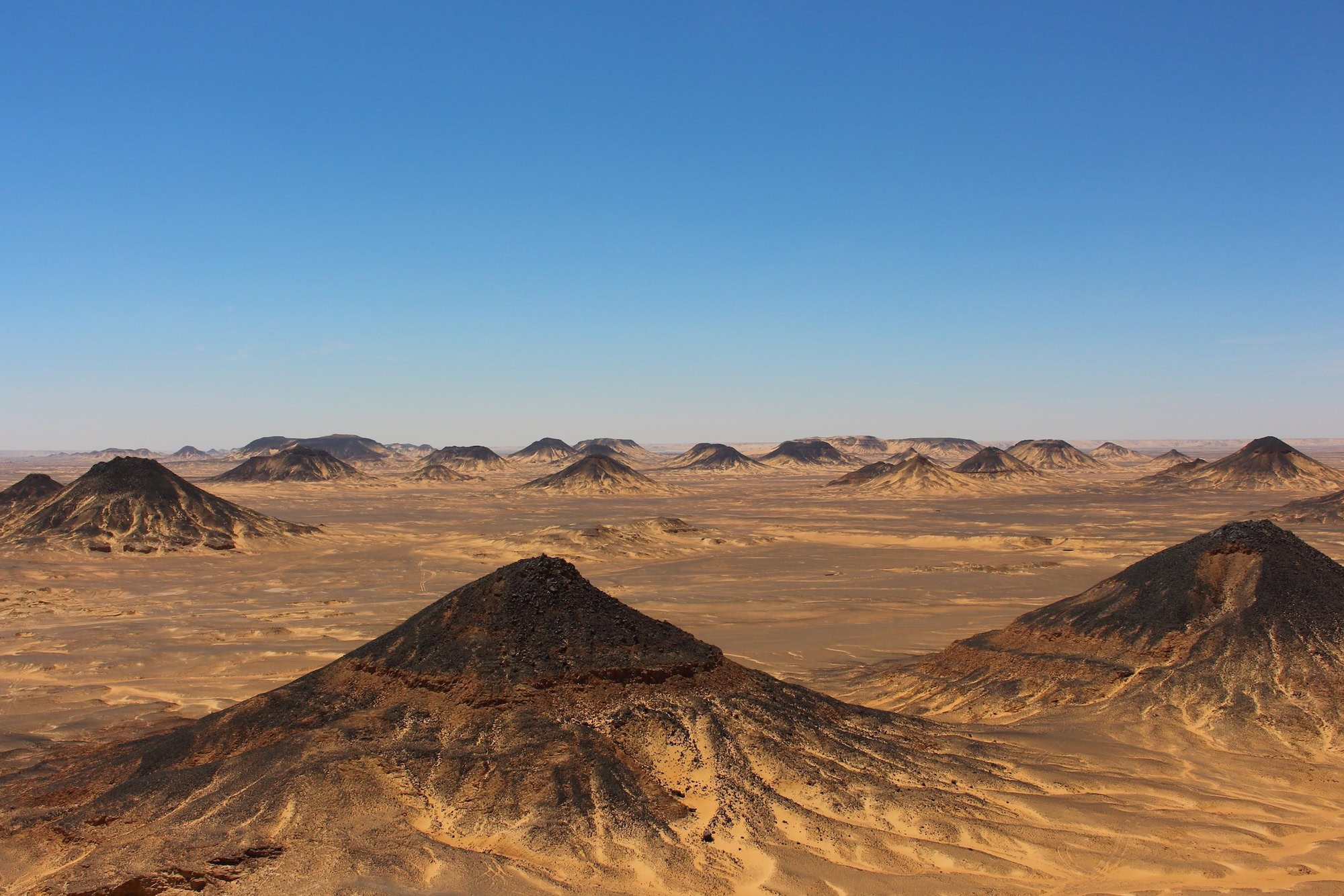 Black Desert landscape with volcanic hills and rocky formations in Egypt